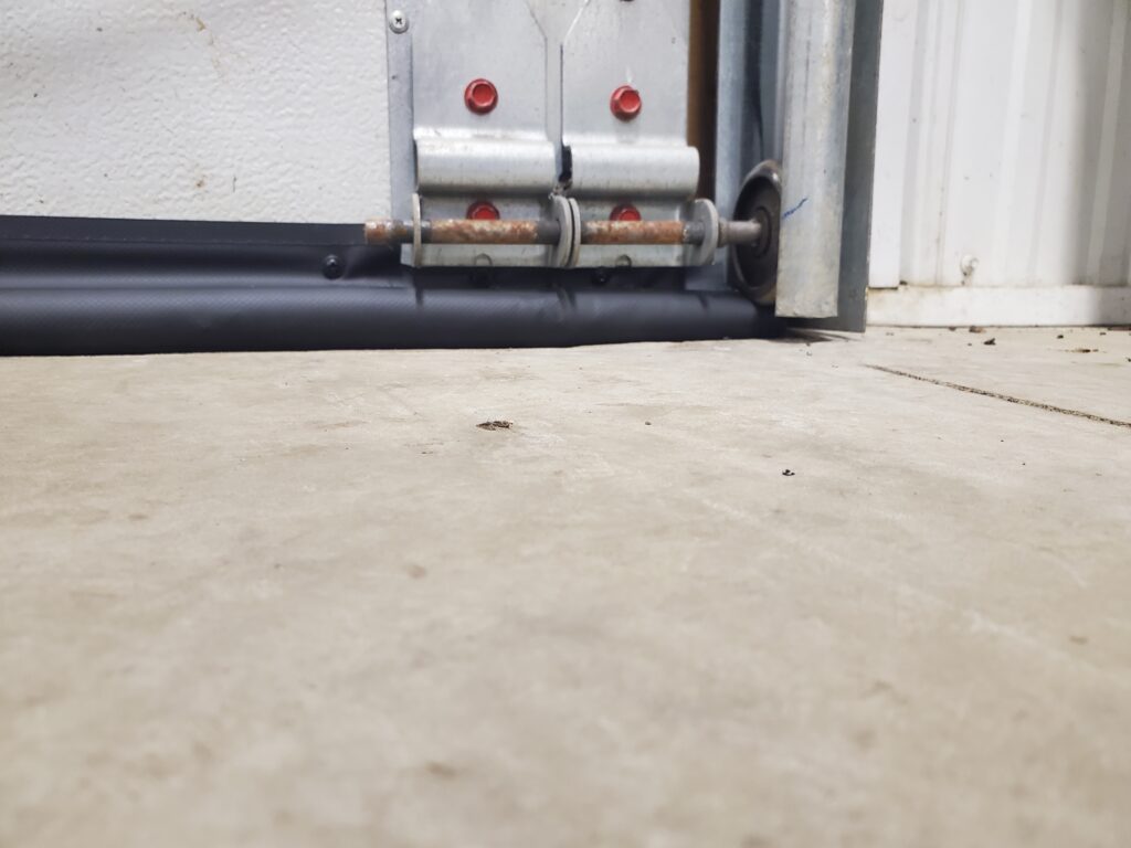 SnirtStopper Original BottomSealer shown installed past garage door edge